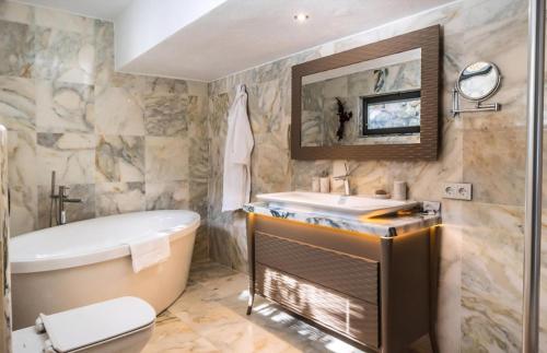 a bathroom with a tub and a toilet and a sink at Kalkan Regency in Kalkan