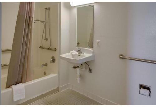 a white bathroom with a sink and a shower at Motel 6 Gulfport, MS Airport in Gulfport