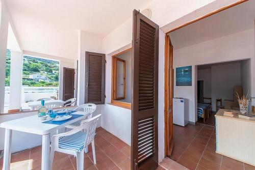 a kitchen and dining room with a white table and chairs at B&B Hotel Il Veliero - la vela del veliero in SantʼAndrea