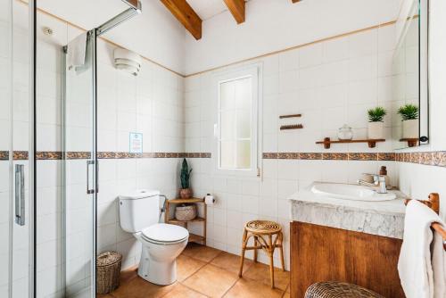 a bathroom with a toilet and a sink at Villa Rouss by Escape Home in Cala en Porter