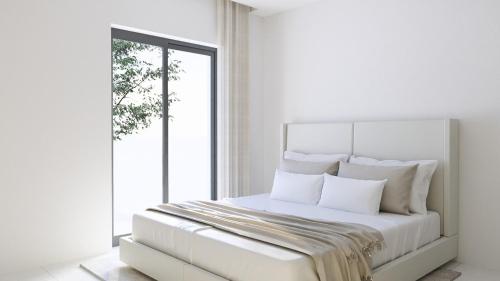 a white bedroom with a white bed with a window at Ferienwohnung Apartment am Moosrain in Eitting