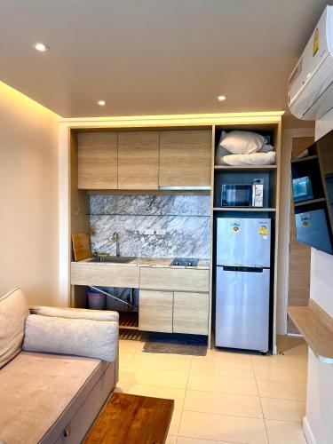 a kitchen with a refrigerator and a couch in a room at Coconut Suite Aonang in Ao Nang Beach