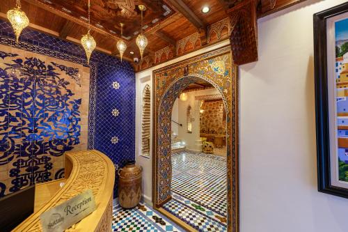 a bathroom with blue and white tiled walls and a mirror at Riad Sultan Chefchaouen in Chefchaouen