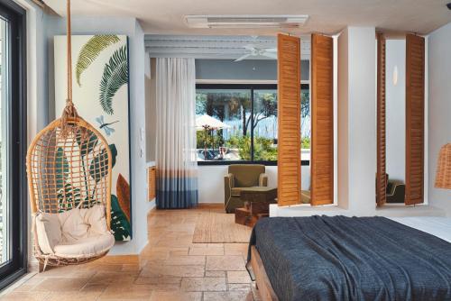 a bedroom with a bed and a chair and a window at Yacht Boheme Hotel-Boutique Class - Adults Only in Fethiye