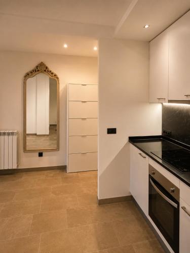 a kitchen with white cabinets and a mirror at Residencial Lleida in Lleida