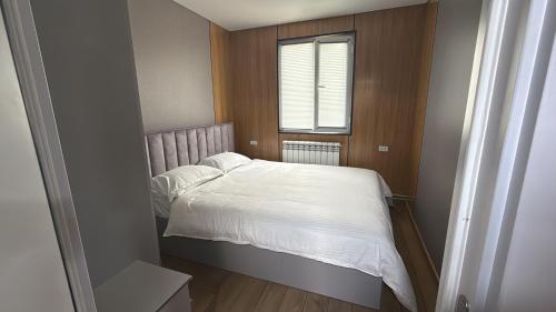 a small bedroom with a bed and a window at Opensky-kolsay 2 in Saty