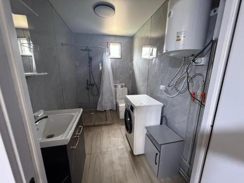 a bathroom with a sink and a washing machine at Opensky-kolsay 2 in Saty