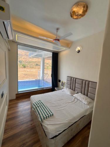 a bedroom with a bed and a large window at Avera luxurious stay in Igatpuri