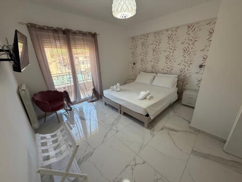 a bedroom with a bed and a chair and a window at Clara Apartment in Parghelia