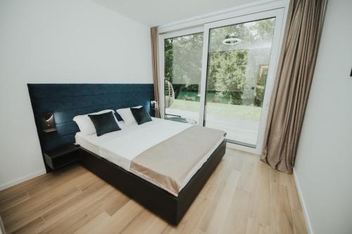 ein Schlafzimmer mit einem Bett und einem großen Fenster in der Unterkunft Home Libre in Bosanska Krupa