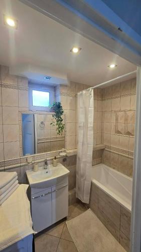 a bathroom with a tub and a sink and a bath tub at Via VOLTA 2025 Refresh 2 Bedroom Apartment in Płock