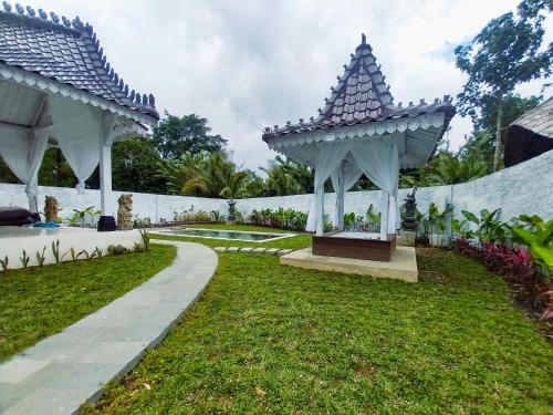a garden with two gazebos and a path at Hafrana Villa by AGATA - 700sqm 2BR Villa with Private Pool & Jacuzzi in Sidemen