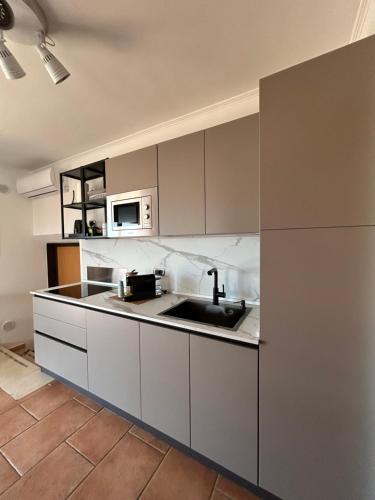 a kitchen with a sink and a microwave at AtticoCinque in Bari