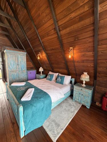 a large bed in a room with wooden walls at Bona Dea in Cayeli