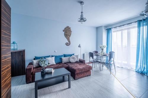 a living room with a couch and a table at Sztutowo Lazurowy Dwór - Apartamenty oraz Pokoje z Parkingiem in Sztutowo