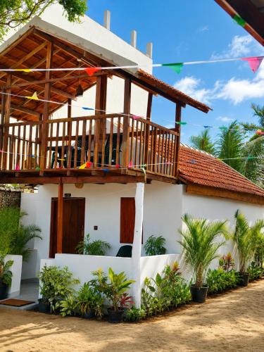 a house with a deck on top of it at Surf Wave Hotel in Arugam Bay