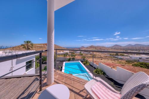 a balcony with chairs and a swimming pool at Villa El Erizo - Pool By Lanzarote Vacation Homes in Nazaret