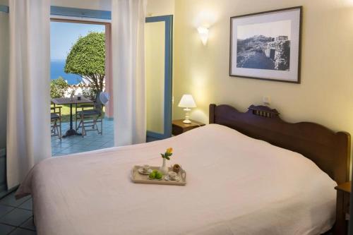 a bedroom with a bed with a view of a patio at MIRA Resort Maizonettes in Lefkada