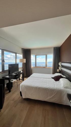 a bedroom with a bed and a desk with a computer at Hotel Carqueijais - Serra da Estrela in Covilhã