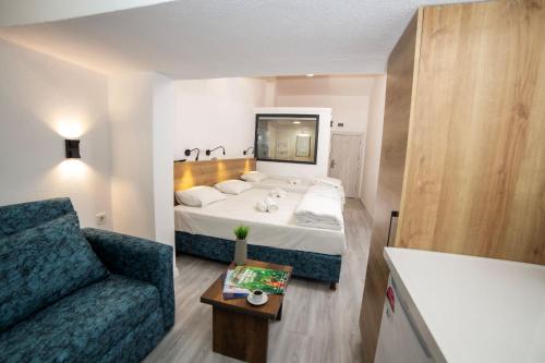 a small bedroom with a bed and a couch at Bluetopas Otel in İskele