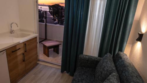 a bathroom with a sink and a couch and a window at Bluetopas Otel in İskele