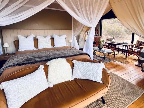 a bedroom with a large bed and a couch at Tula Retreat - Secluded Karoo Escape - Hot Tub - Private Boat Arrival in Calitzdorp