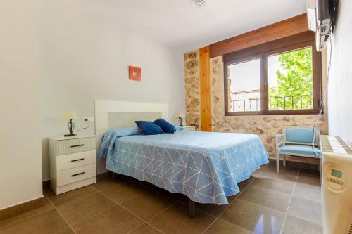 a bedroom with a bed and a window and a chair at Precioso Apartamento a estrenar. La Placeta in Riópar