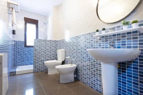 a blue tiled bathroom with a sink and a toilet at Precioso Apartamento a estrenar. La Placeta in Riópar