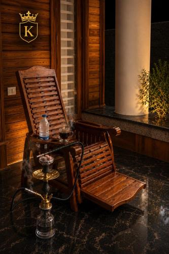 a wooden chair and a table with a bottle of water at Kings Castle in Varkala