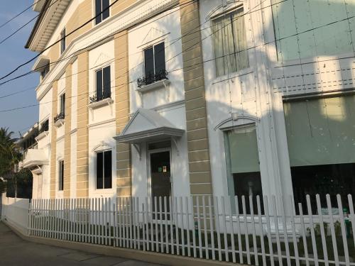 a building with a white fence in front of it at Daffodils Spice Court in Cochin