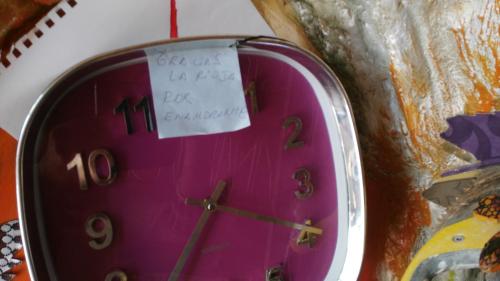 a pink clock with a piece of paper on it at Anahuaska Art - Suites Temáticas in Panzares