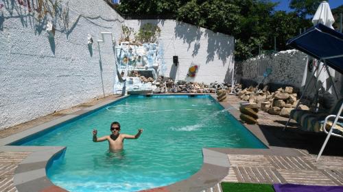 a man standing in a pool in a swimming pool at Anahuaska Art - Suites Temáticas in Panzares