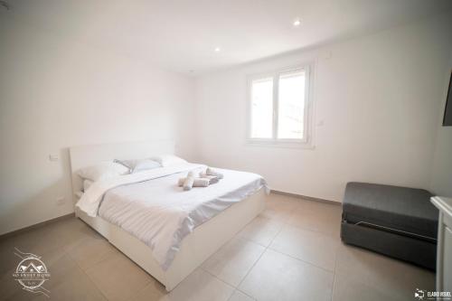 a bedroom with a white bed with a teddy bear on it at Les Embruns - Mer - Terrasse in Le Grau-du-Roi