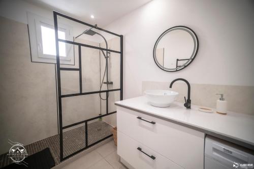 a bathroom with a sink and a shower with a mirror at Les Embruns - Mer - Terrasse in Le Grau-du-Roi
