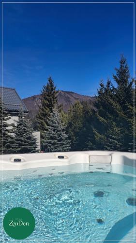 a large swimming pool with trees in the background at Sinaia ZenDen - Private Villa & SPA in Sinaia