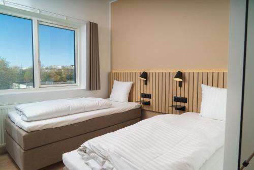 two beds in a room with a window at Easy Stay Næstved in Næstved