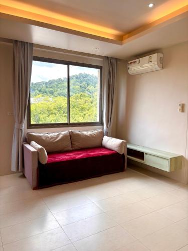 a couch in a room with a large window at Coconut Condo Aonang in Ao Nang Beach
