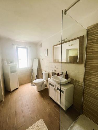 a bathroom with a toilet and a sink and a shower at Hideaway Haven Villa in SantʼAnna Arresi