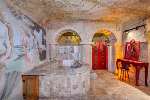 a bathroom with a sink and a red door at The Calypso Cave in Ürgüp