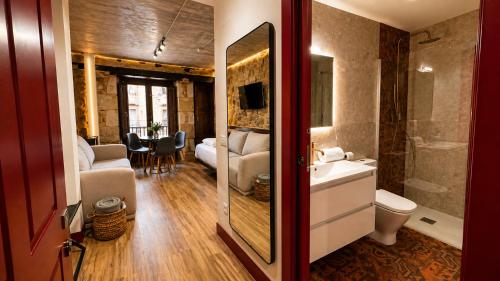 a bathroom with a sink and a toilet and a tub at Rua Mayor MSuites in Salamanca