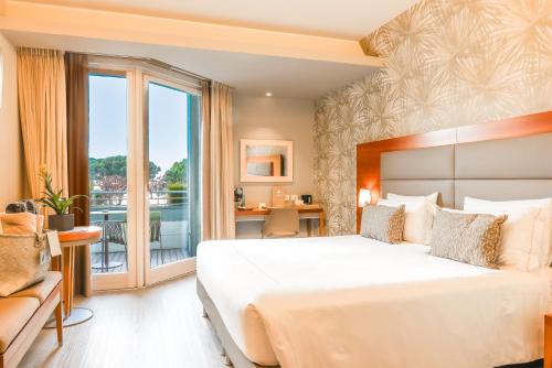 a bedroom with a large bed and a balcony at Hotel Corte Valier in Lazise