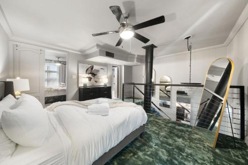 a bedroom with a bed and a ceiling fan at Spacious Loft Condo w Pool & Fireplace in Dallas