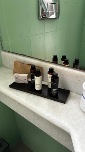 a shelf with four bottles on it in front of a mirror at Maryo Village in Naousa