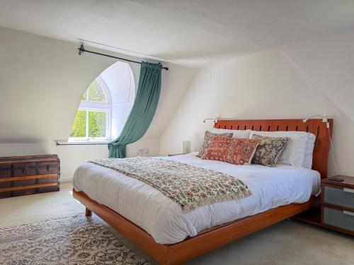 a bedroom with a large bed and a window at Foresters Cottage, Dalry in Dalry
