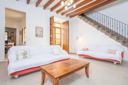 a living room with two white couches and a wooden table at Can Romaguera in Algaida