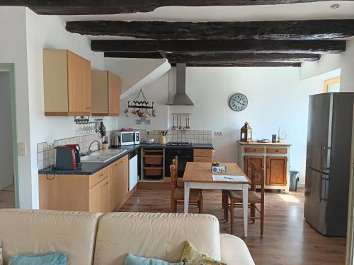 a kitchen and living room with a couch and a table at Maison Bretagne in Bourseul