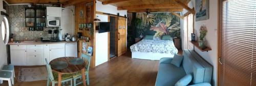 a kitchen with a table and a bedroom with a bed at Kajüt Apartman in Balatonfenyves
