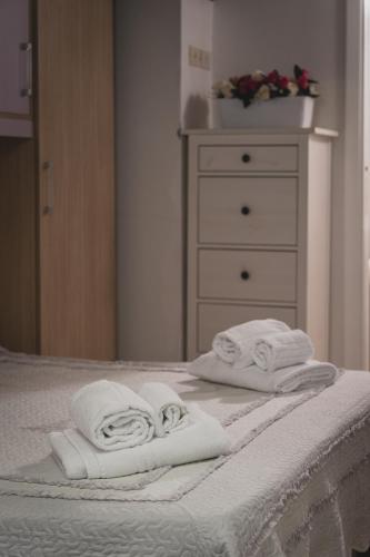two towels are sitting on a bed with a dresser at Bargello House by FrancigenaApartments in Siena