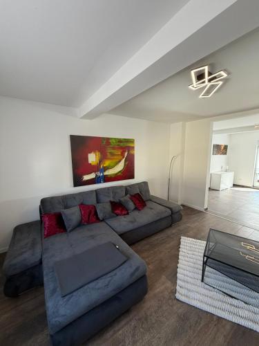 a living room with a gray couch and red pillows at Ferienwohnung RaHo in Wadgassen