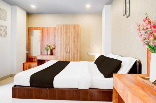 a bedroom with a large bed with white and black sheets at Hotel Pratishtha in Guwahati